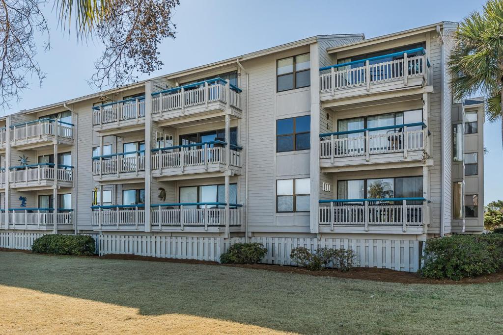 an apartment building with balconies and a palm tree at Direct Ocean View! M Building Pool and Ocean Views in Harbor Island