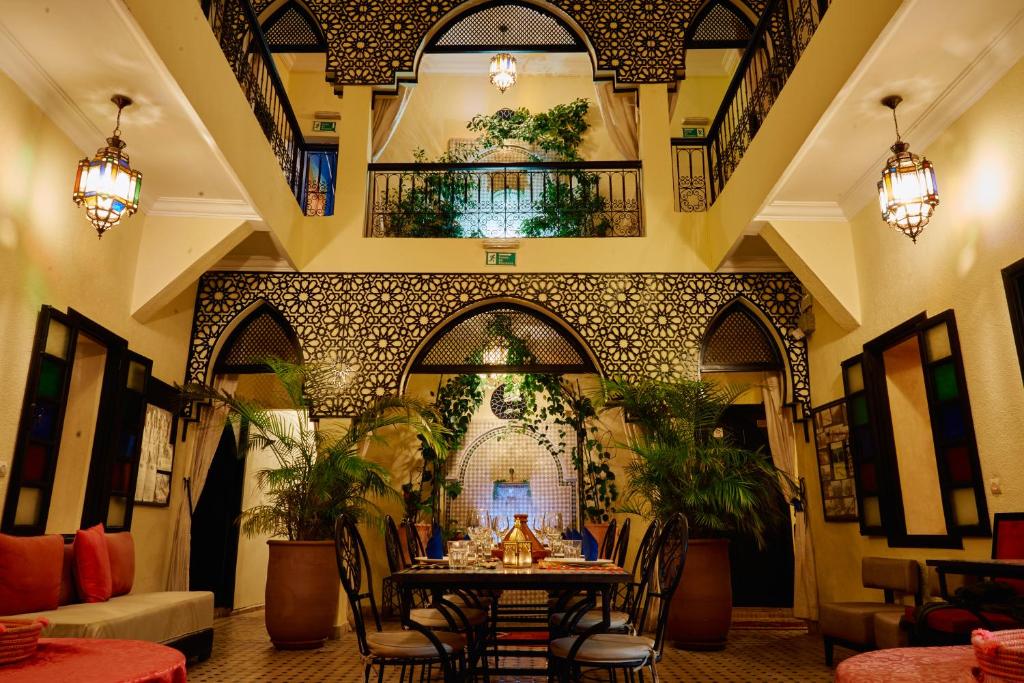 a restaurant with a table and chairs in a building at Riad Dar La Rose in Marrakech