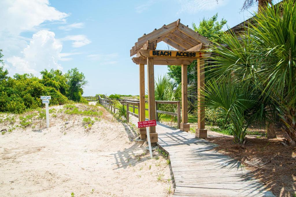 a sign for a beach next to a wooden walkway at Direct Ocean View! M Building Pool and Ocean Views in Harbor Island