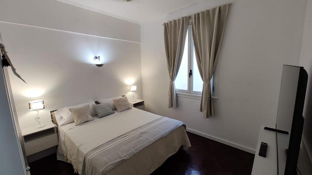 ein weißes Schlafzimmer mit einem Bett und einem Fenster in der Unterkunft Palermo Soho, Oh! Mi lugar favorito in Buenos Aires