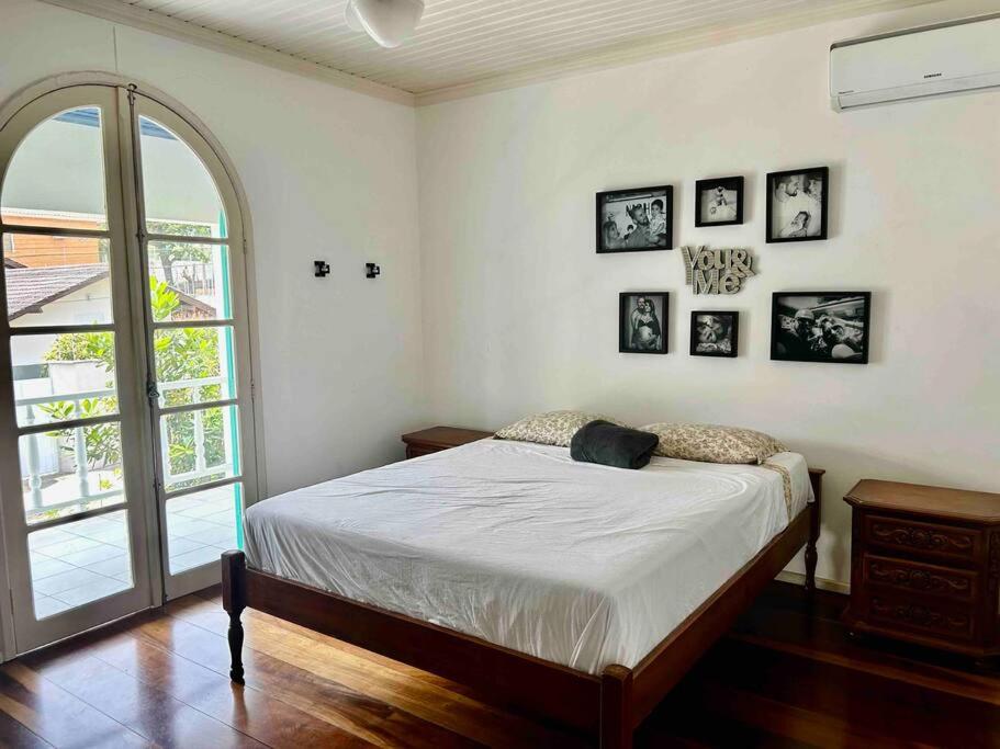 um quarto com uma cama e algumas fotografias na parede em Casa Canasvieiras Florianópolis com piscina e mar em Florianópolis