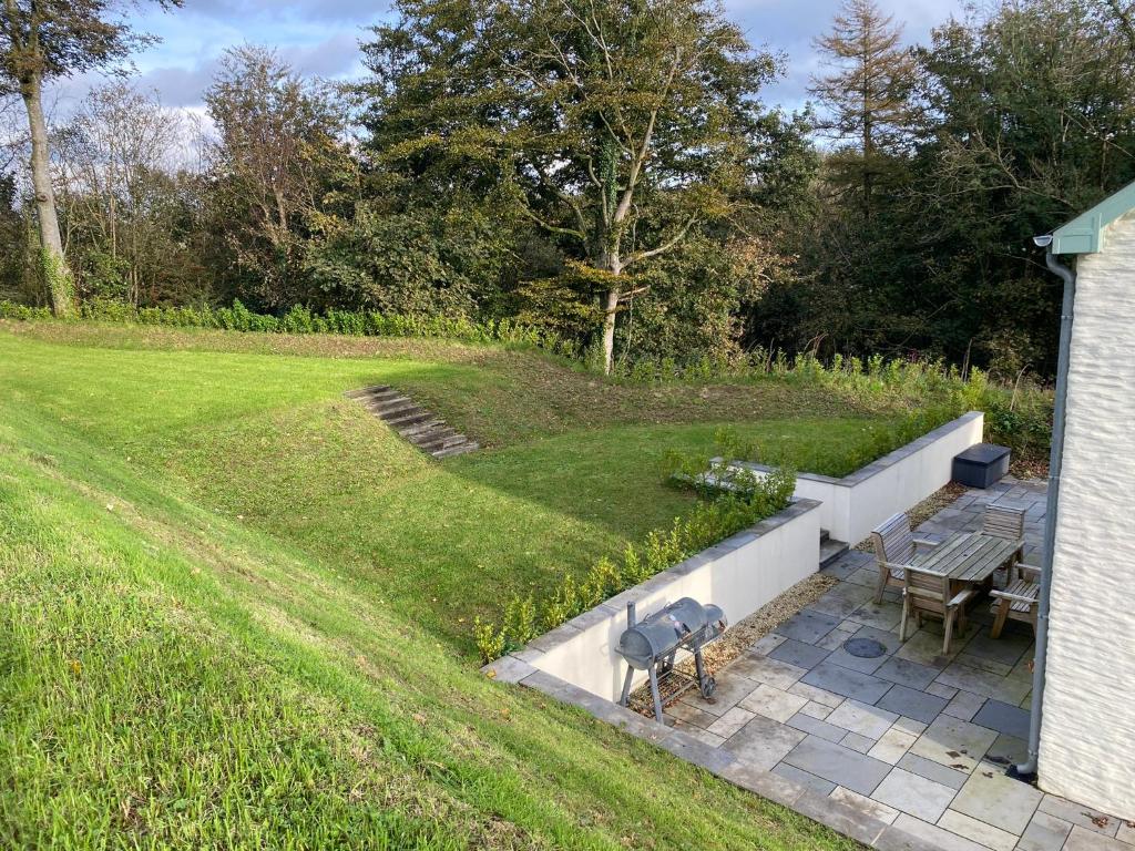 a patio with a table and a grill in a yard at Kilbarth Cottage in Haverfordwest