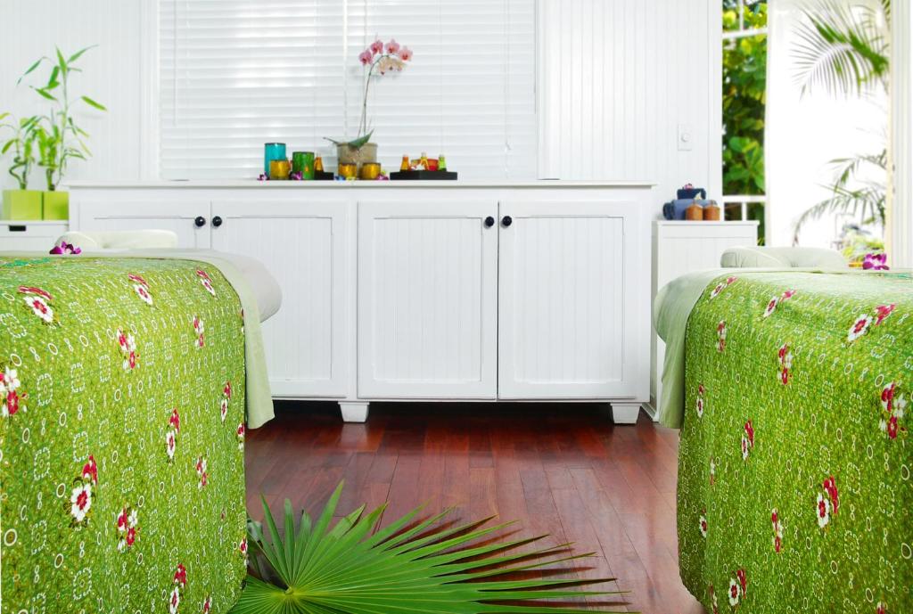 a kitchen with white cabinets and a green couch at Ocean Key Resort & Spa, a Noble House Resort in Key West