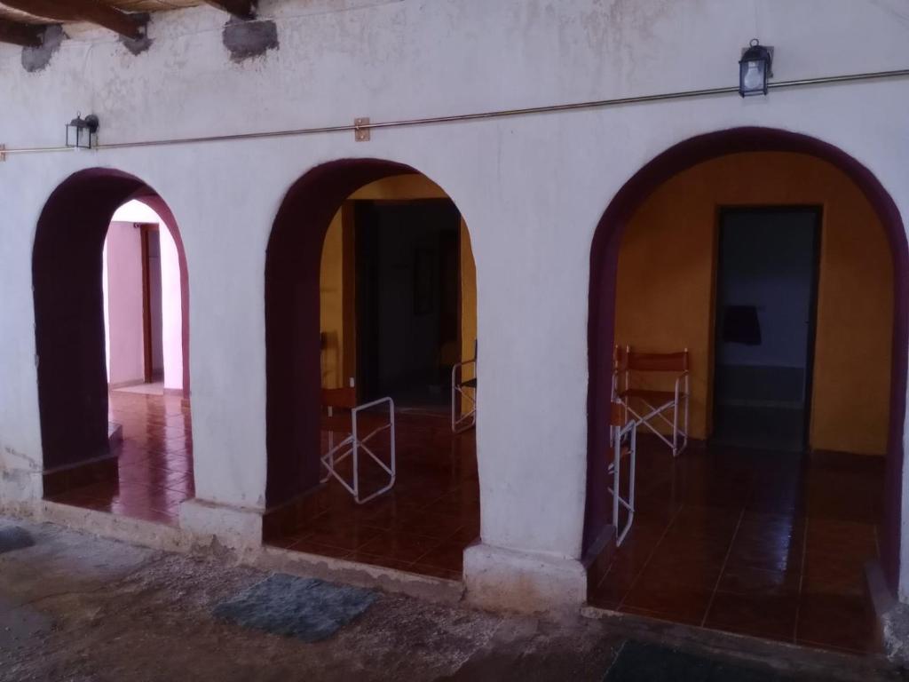a room with three arches on the side of a building at POSADA CUATRO HERMANOS in Tinogasta