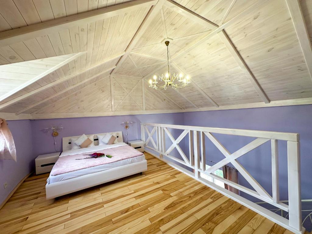 - une chambre avec un lit, des murs violets et un plafond dans l'établissement Na Pagorbi Lutsk, à Loutsk