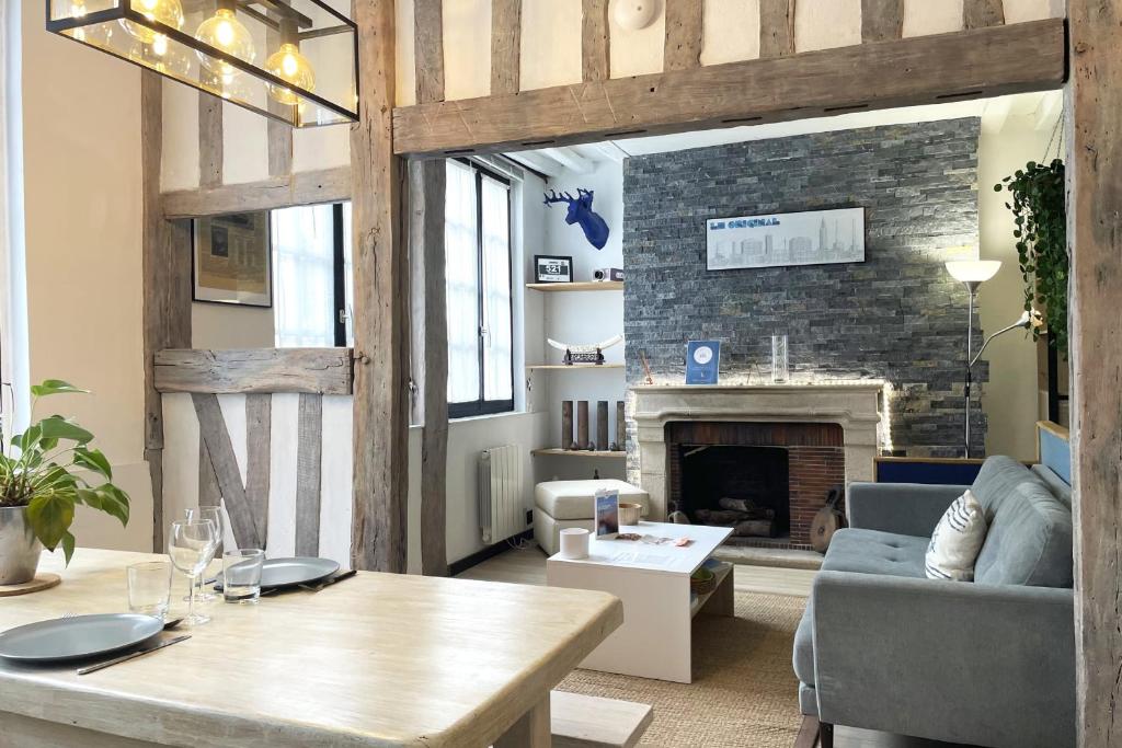 un salon avec une table et une cheminée dans l'établissement L'île Enchantée - Typique - St François, au Havre