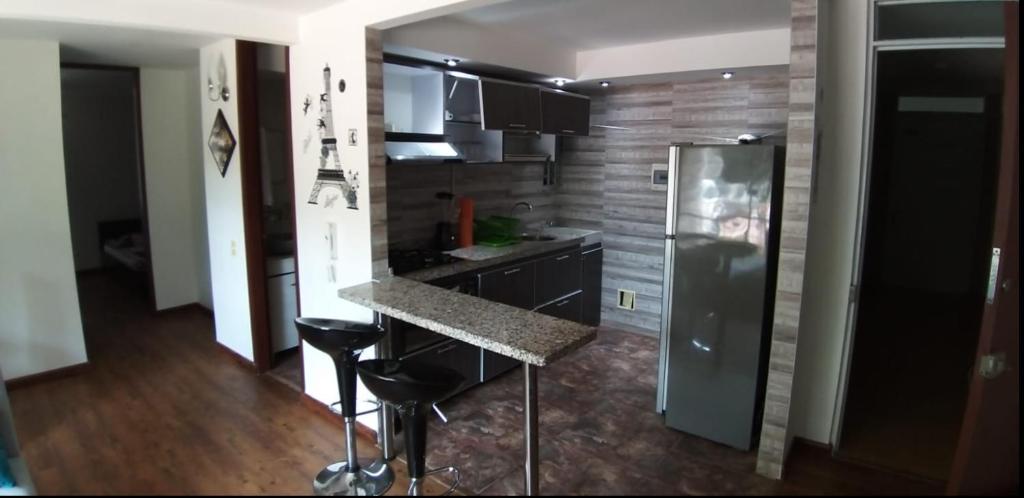uma cozinha com um balcão e um frigorífico em Apto en conjunto cerrado con piscina. em Ricaurte