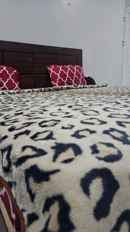 a bedroom with a bed with a black and white blanket at Luxury Hotel Rooms in Karachi