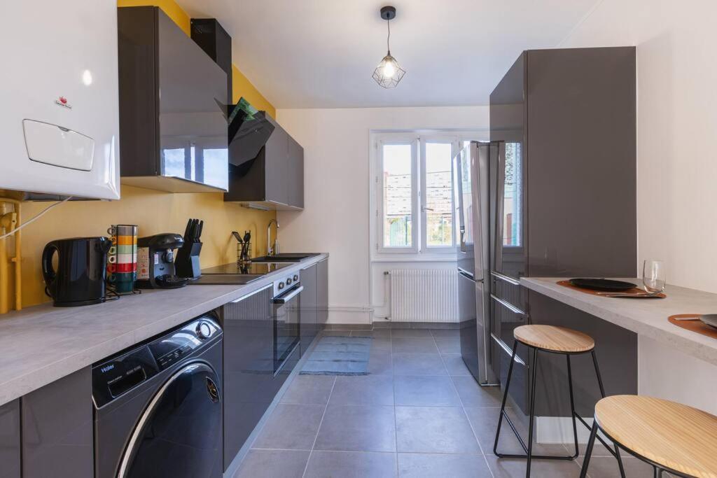 a kitchen with a washer and a dishwasher at Appartement meublé Wifi&#47;Balcon&#47;parking Clermont in Clermont-Ferrand