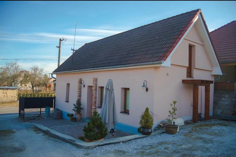 mały biały dom z czarnym dachem w obiekcie Ubytovanie Nitrianske Pravno w mieście Prievidza