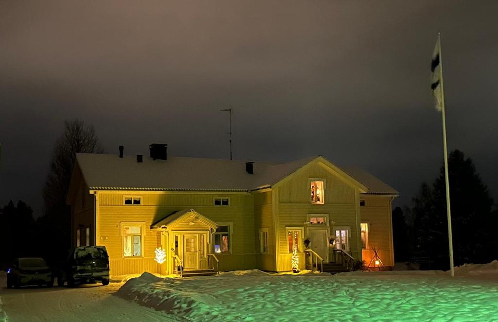 een geel huis in de sneeuw 's nachts bij Liepeen pappila in Pudasjärvi
