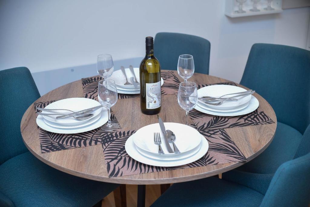 a wooden table with plates and a bottle of wine at Zlaribor Breza 5 in Čajetina