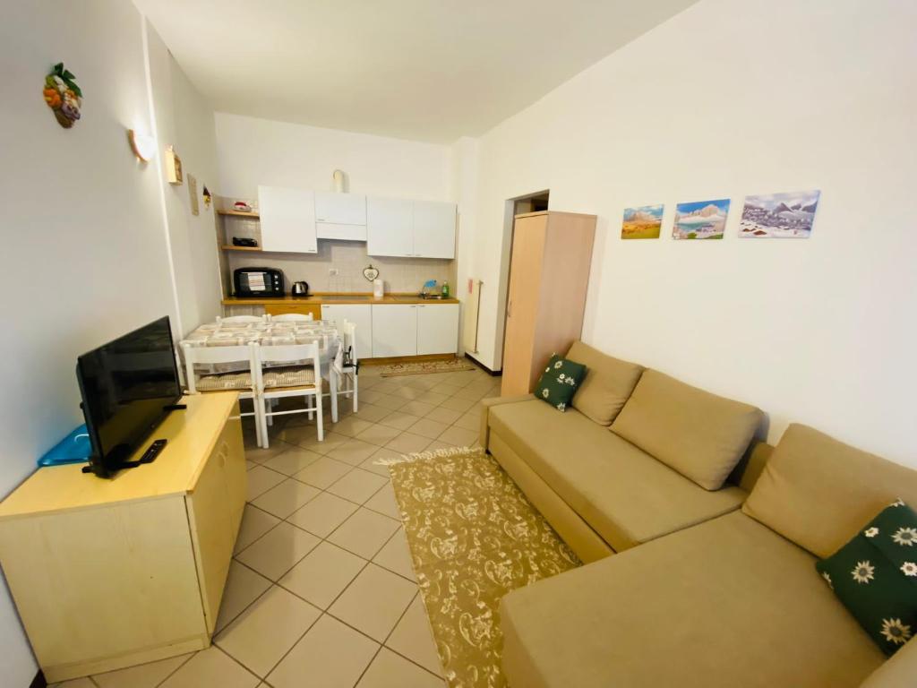 sala de estar con sofá y cocina en Bilocale a Mazzin, en Campestrin
