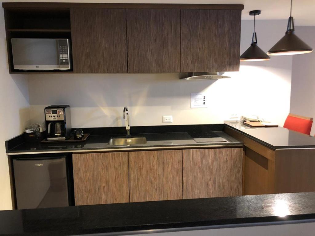 A compact in-room kitchenette with a sink, microwave and coffee maker.