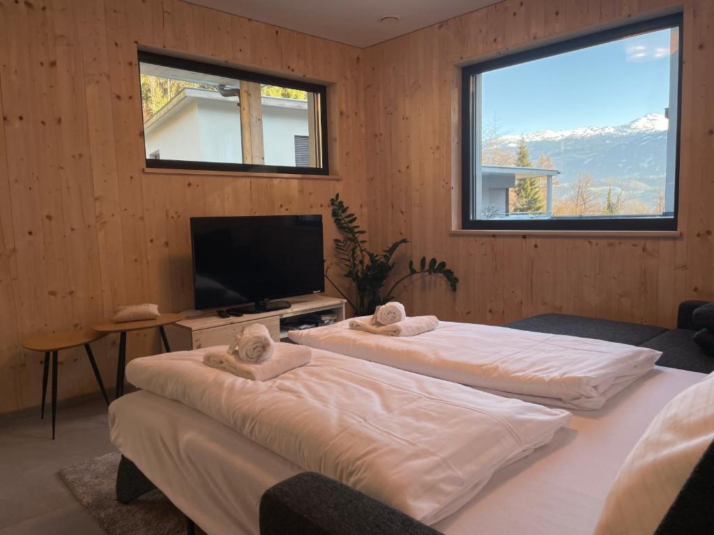 Duas camas num quarto com uma televisão de ecrã plano em Waldblick - modern wohnen - Self-Check-In - direkt am Wald - kein Verkehr - in 10 Minuten im Innsbrucker Zentrum - vorm Haus parken em Innsbruck