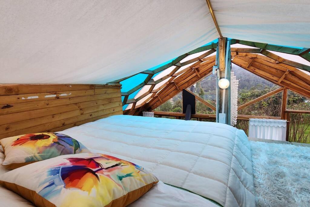 a bedroom with a bed in a tent at Ecocasa del Encuentro: única y confortable in La Calera