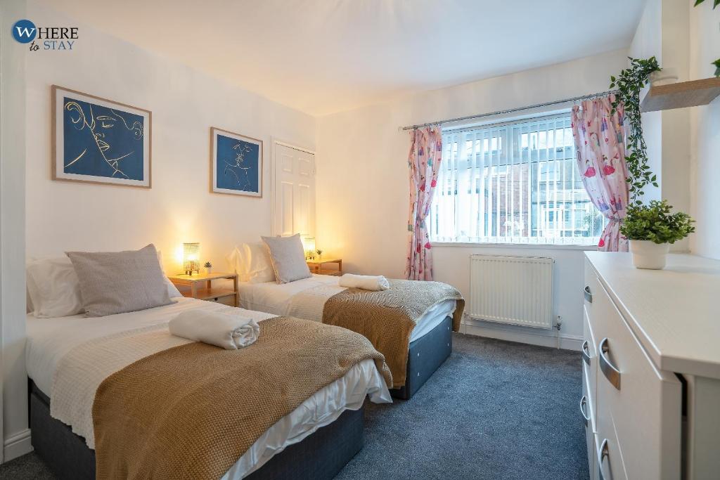 a bedroom with two beds and a window at Gorgeous 2 bed apartment Durham 
