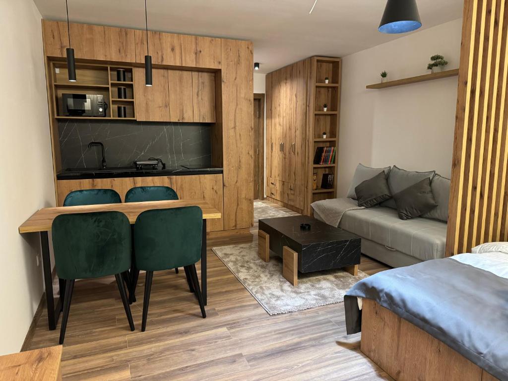 a living room with a table and chairs and a couch at Grand Apartman Kopaonik in Kopaonik