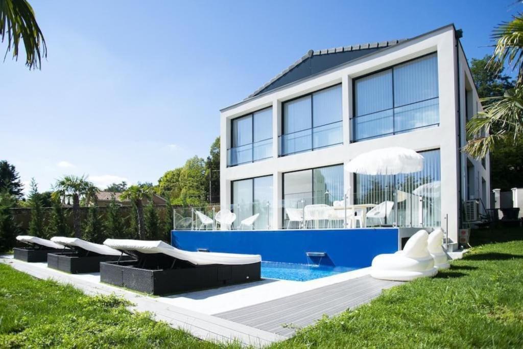 een huis met een zwembad ervoor bij La Maison Blanche in Écully