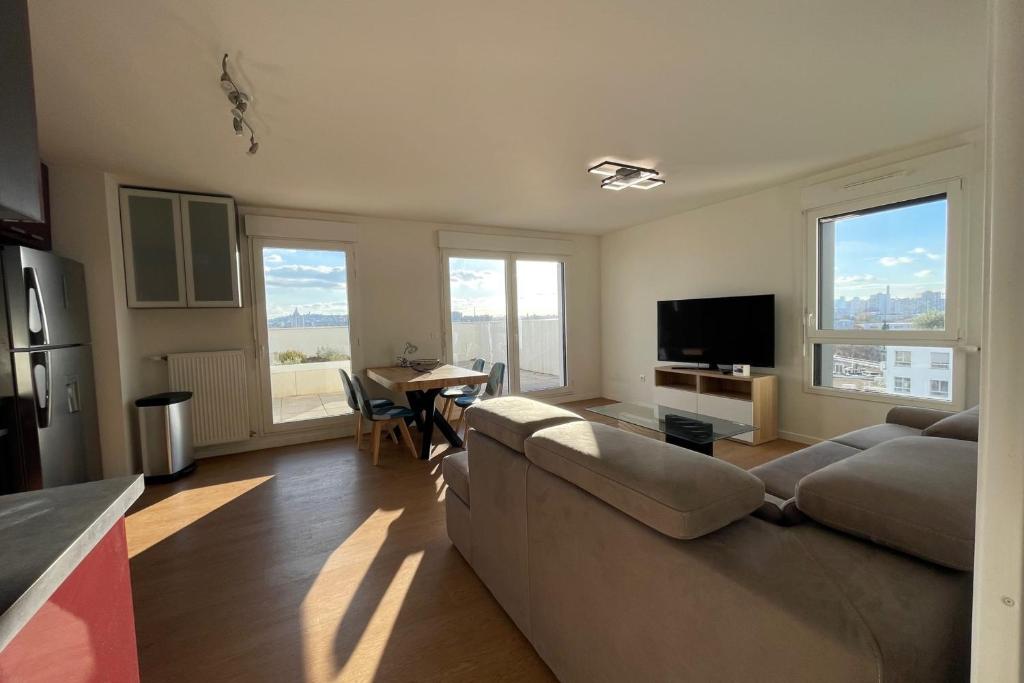 un salon avec un canapé et une table dans l'établissement Spacious flat with terrace, à Saint-Denis