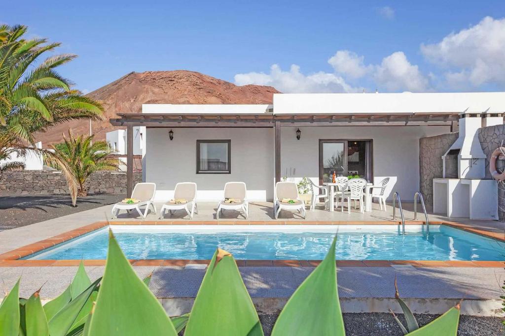 a villa with a swimming pool in front of a house at Villas Rodríguez in Playa Blanca
