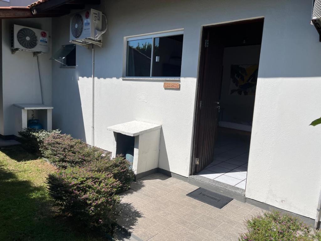 uma porta para uma casa com um banco ao lado em Loft Canarinho - Praia do Campeche em Florianópolis