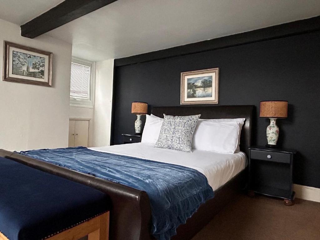 a bedroom with a large bed with a blue blanket at Fairlawn House in Amesbury