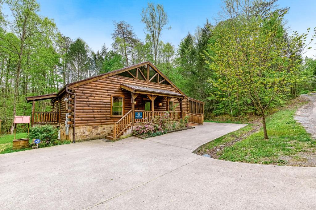 a log cabin in the woods with a driveway at Smoky Bear Cinema in Sevierville