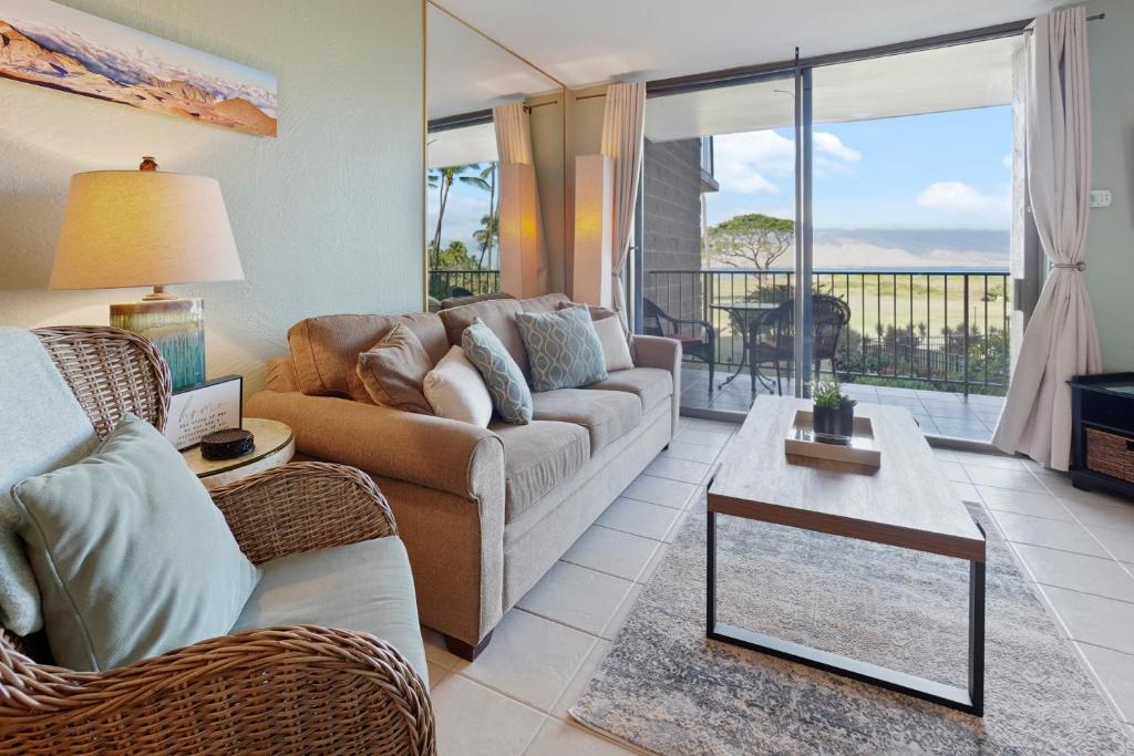 a living room with a couch and a table at Kihei's Seaside Siesta: Ocean View Lanai & Pool in Kihei
