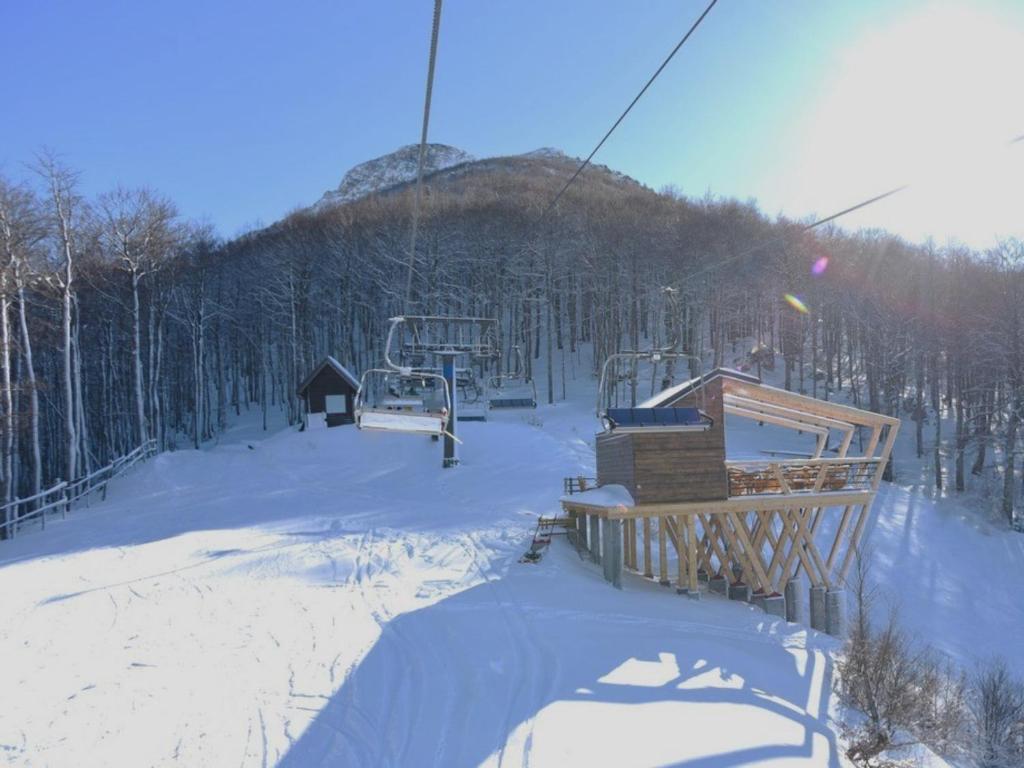 a ski lift with a snow covered mountain in the background at Villa Anemar in Blidinje