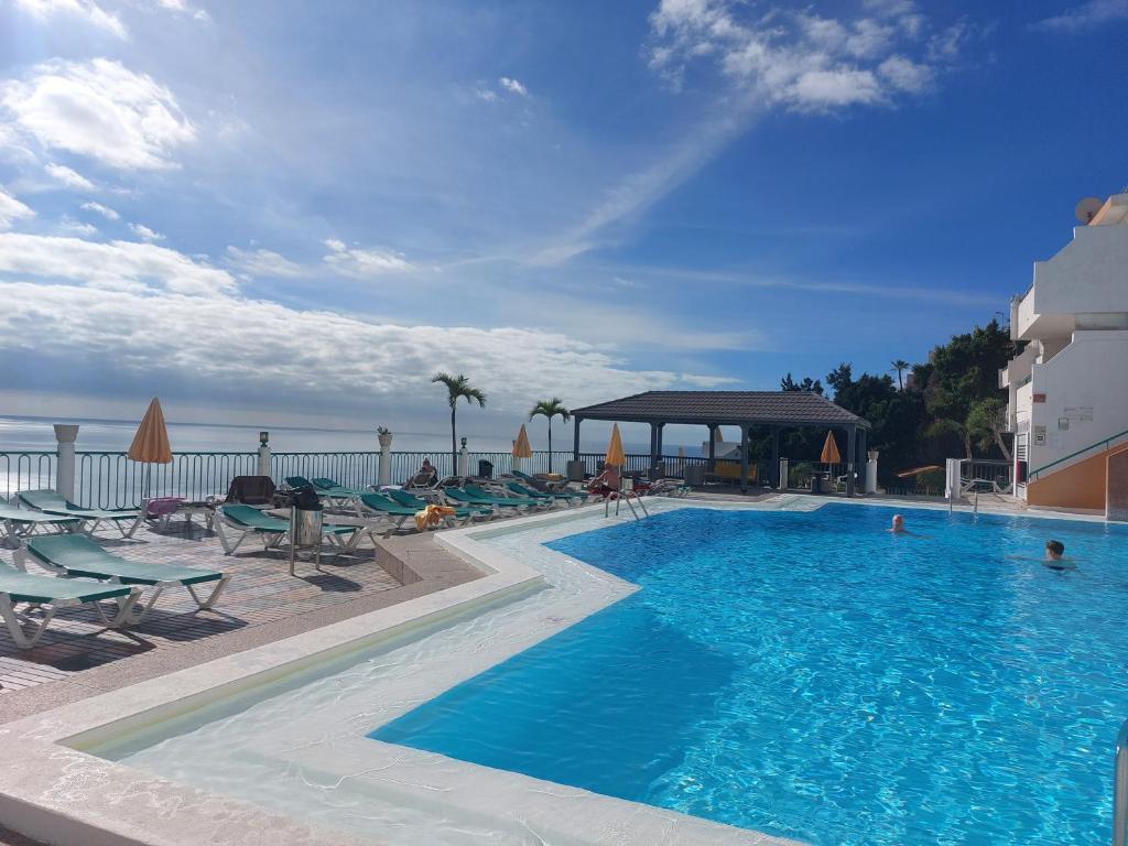 una gran piscina con sillas y el océano en Francesco House 1509 Monte Paraiso Puerto Rico, en Mogán