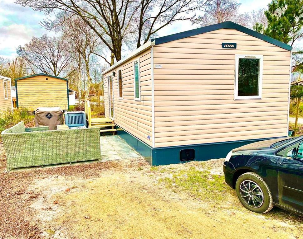 a house with a dog sitting in the front of it at Chalet Jupp in Lauwersoog