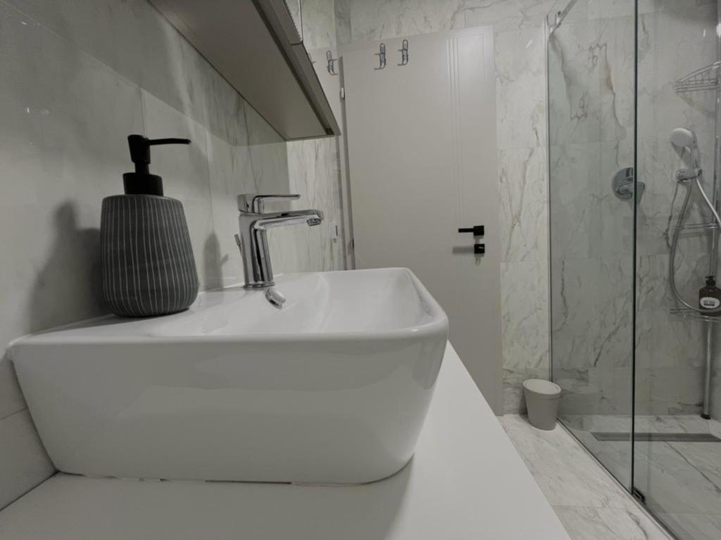 a white bathroom with a sink and a shower at Villa Anemar in Blidinje