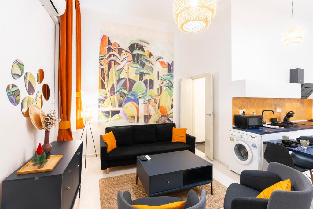 uma sala de estar com um sofá e uma máquina de lavar roupa em Modern uniquely designed flat Andrassy Avenue and Oktogon square em Budapeste