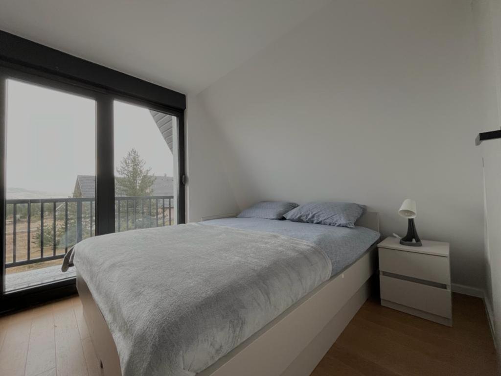 a bedroom with a bed and a large window at Villa Anemar in Blidinje