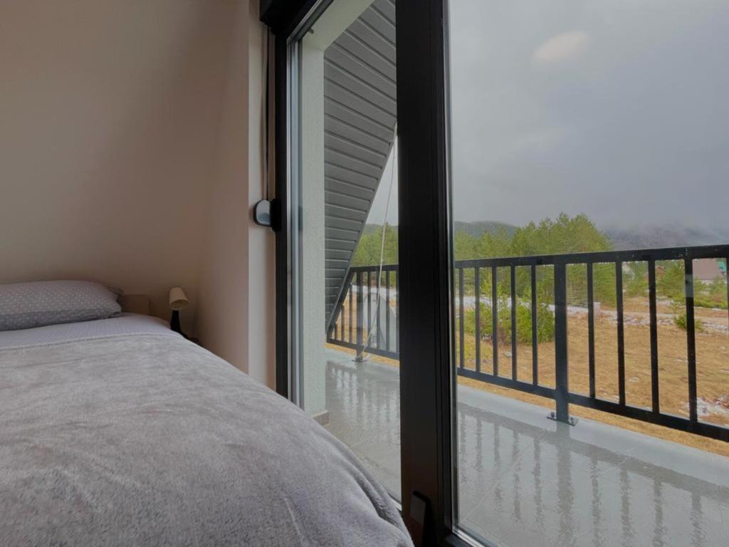 a bedroom with a bed and a large glass window at Villa Anemar in Blidinje