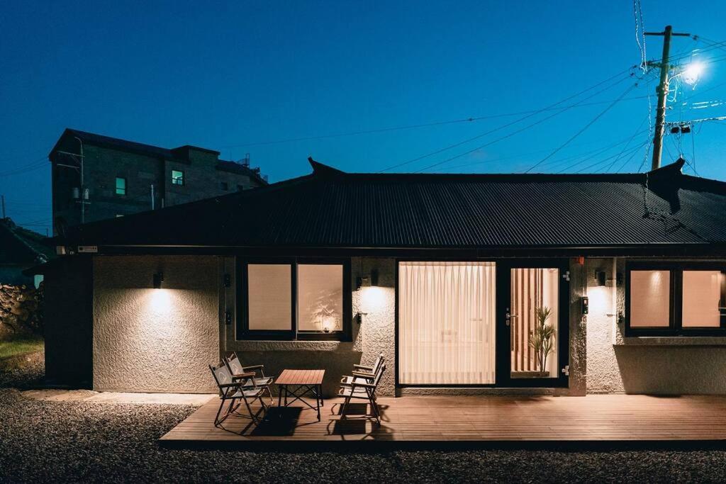 ein Haus mit Stühlen und einem Tisch davor in der Unterkunft Dal Chae in Jeju-do