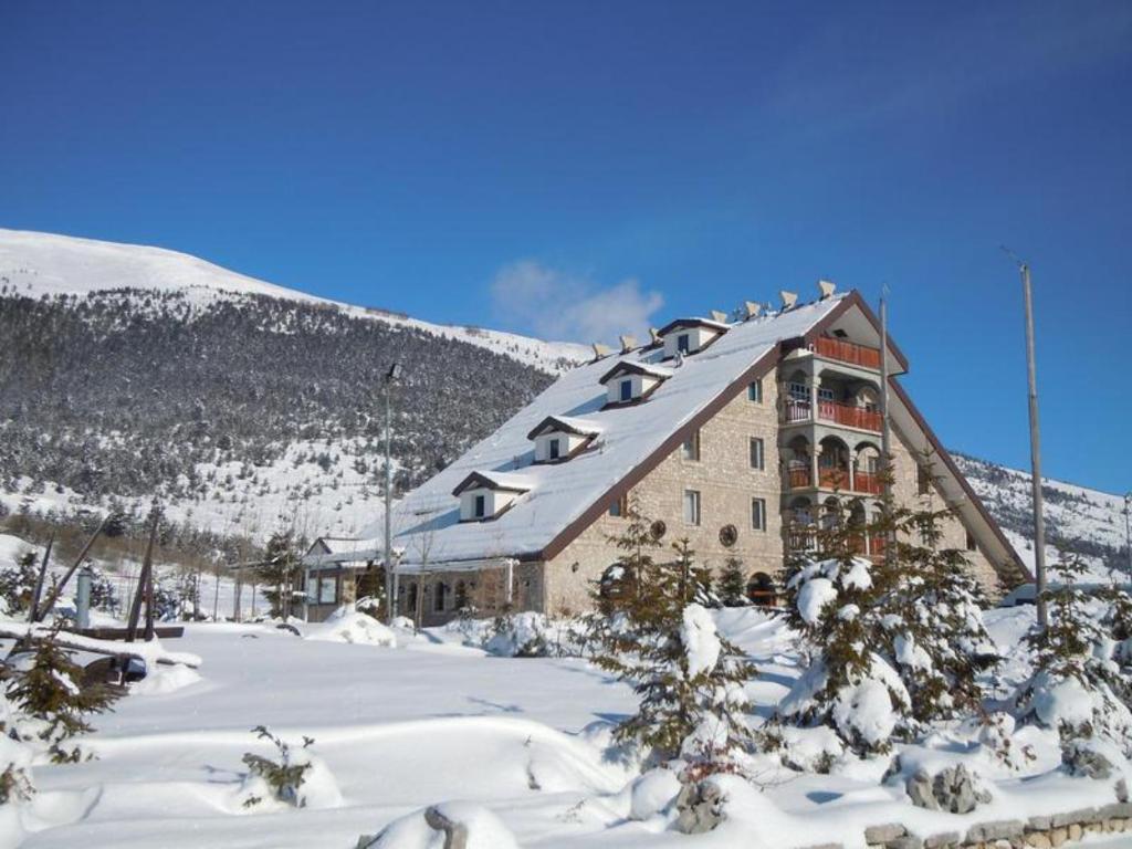 a large building in the snow with a mountain at Villa Anemar in Blidinje