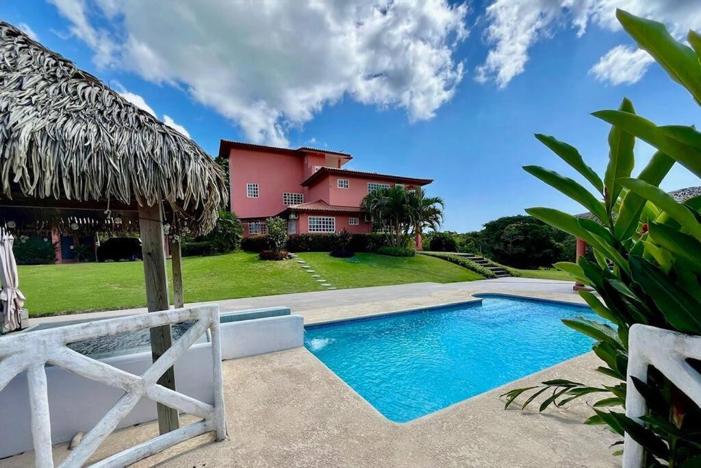 a house with a swimming pool in front of a house at Relaxing family Beach House with Pool in Río Hato