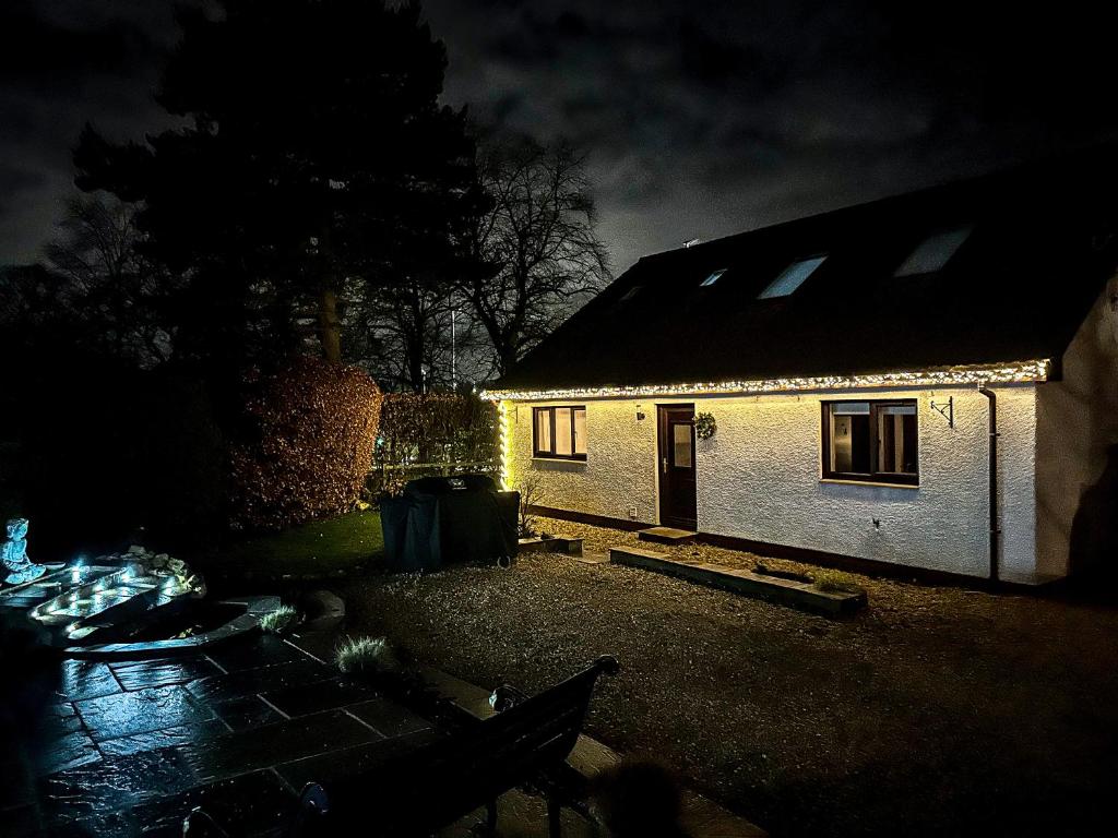 a small white house with lights on it at night at Woodhead view in Kirkintilloch