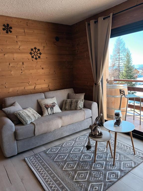 un salon avec un canapé et une table dans l'établissement Appartement montagne LE FLOCON, à Saint-Michel-de-Chaillol