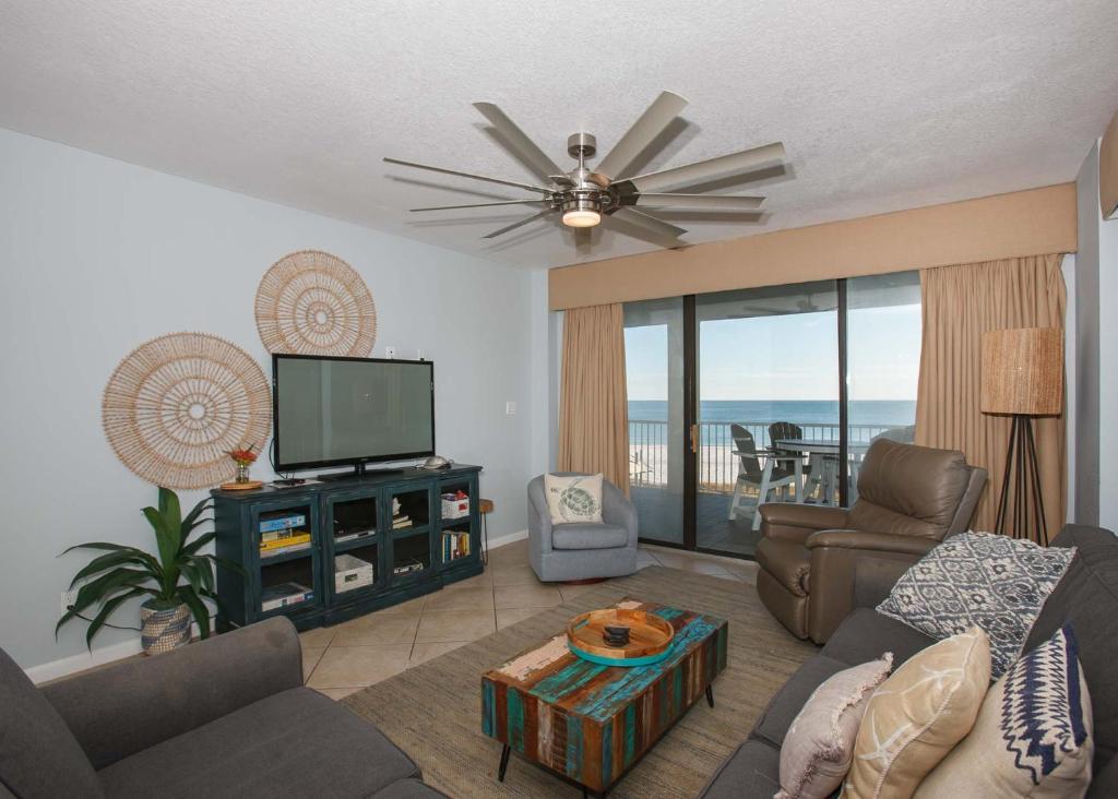 een woonkamer met een bank en een televisie bij Summer House 306A by ALBVR - Corner Beachfront Condo - Beachfront Balcony Accessible from all Rooms in Orange Beach