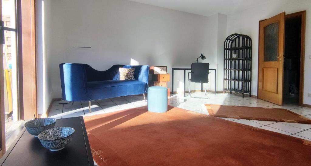 ein Wohnzimmer mit einem blauen Sofa und einem Tisch in der Unterkunft Moderne Maisonette mit Garten in Unterschleißheim