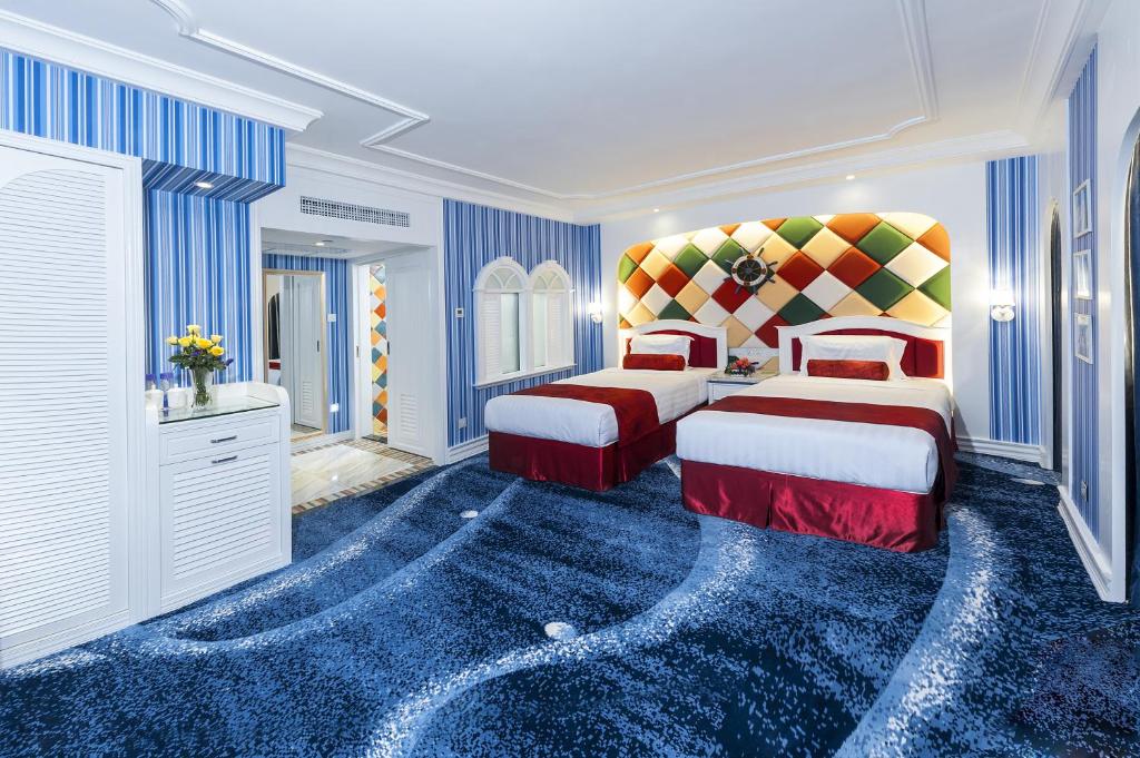 a bedroom with two beds and a blue carpet at Hotel Beverly Plaza in Macau