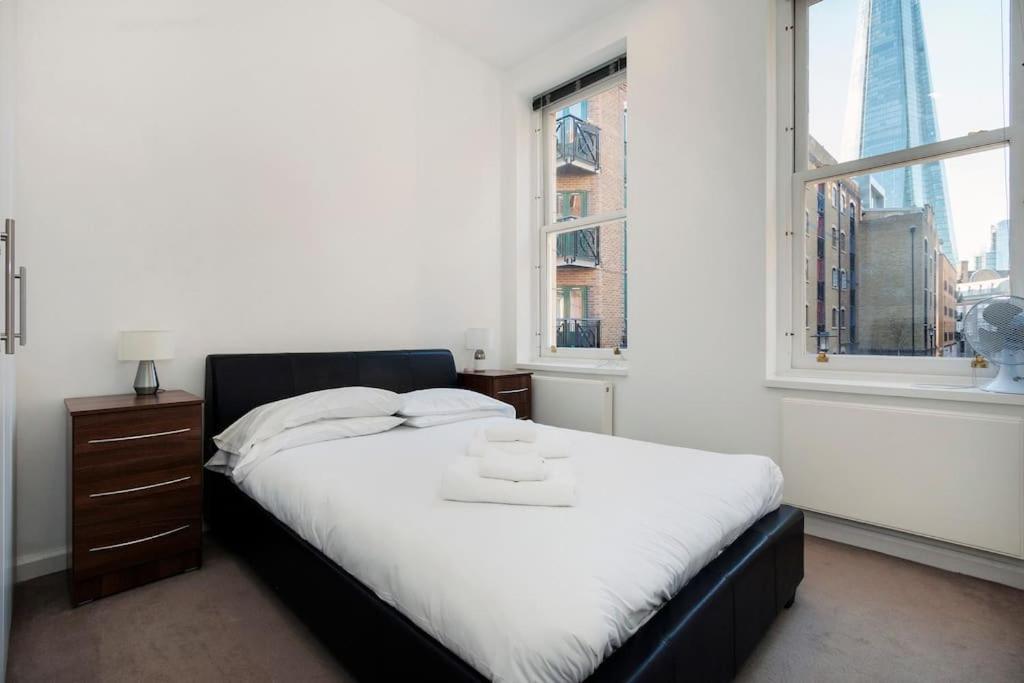 un letto in una camera con una grande finestra di London Bridge Beauty Luxury 2bed 2bath a Londra