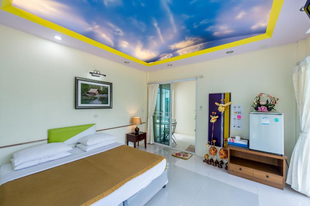 a bedroom with a bed and a ceiling with a sky at Poomvarin Resort in Ban Wang Takhrai
