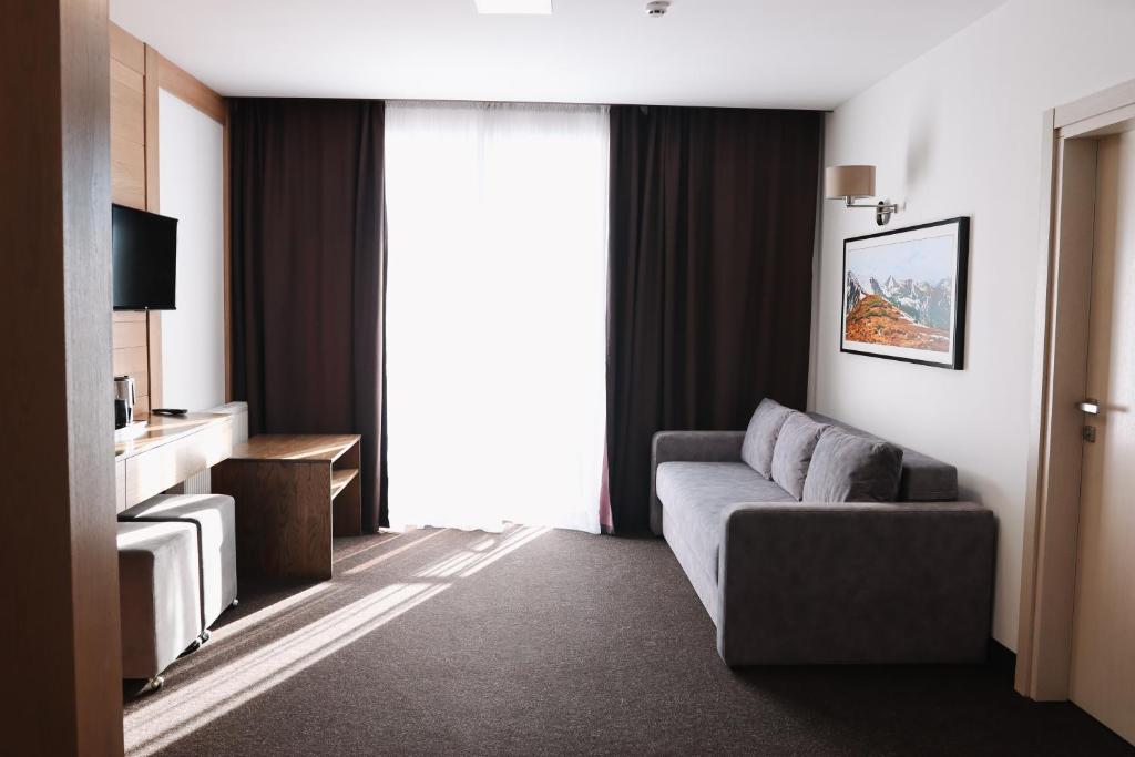 sala de estar con sofá y ventana grande en VILSON hotel, en Bukovel
