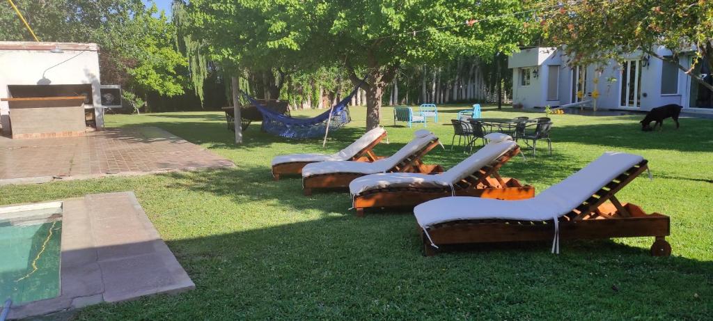 een groep ligstoelen in het gras bij Oasis de Paz Natural in Ciudad Lujan de Cuyo