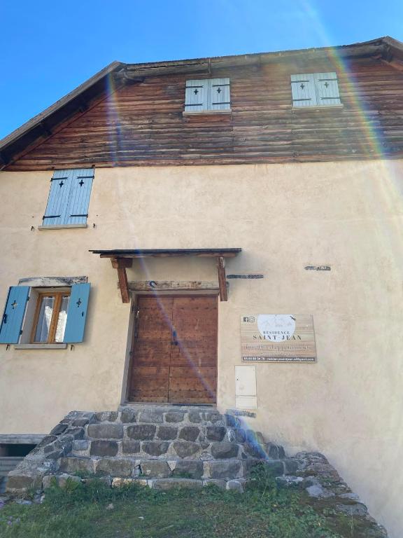 un bâtiment avec un arc-en-ciel devant lui dans l'établissement Résidence Saint-Jean, à Saint-Dalmas-le-Selvage