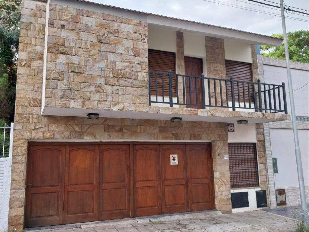a house with two garage doors and a balcony at Departamento premiun Mar de Paz in Santa Teresita